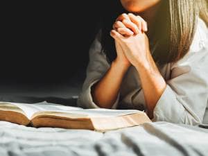 woman praying with the bible